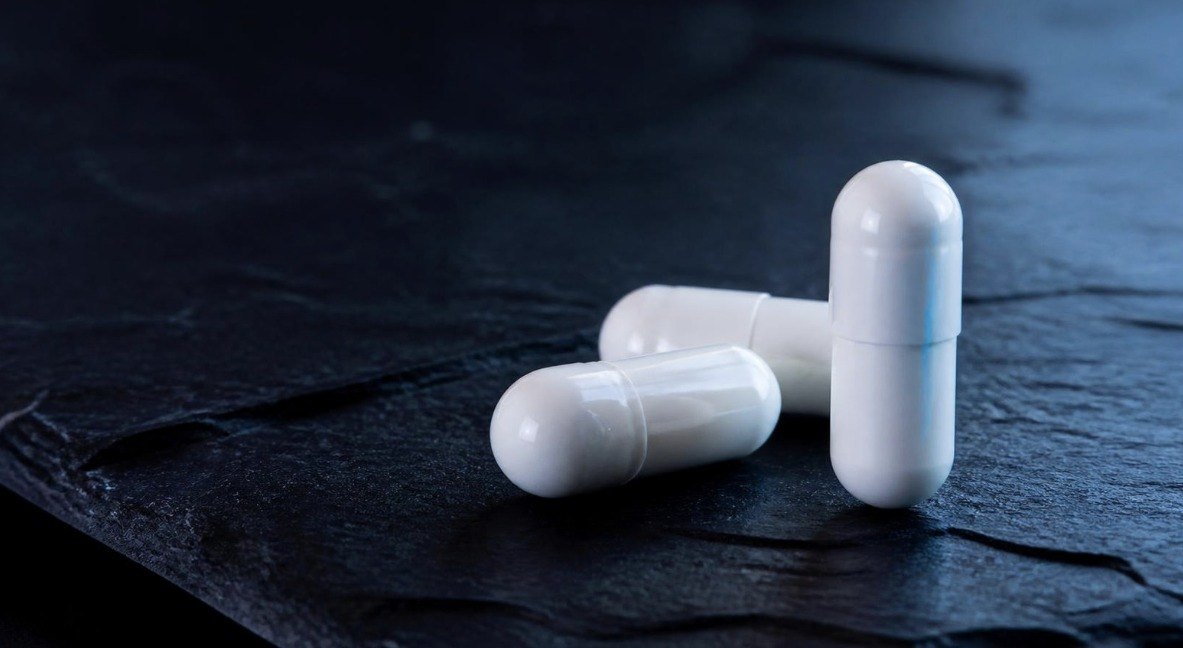 White capsules on dark slate